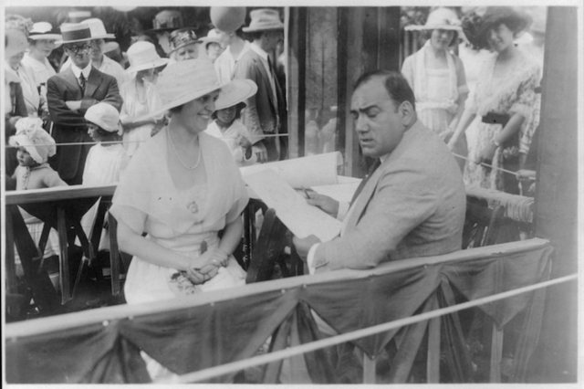Caruso drawing caricature sketches in booth at a charity fair in Southampton, L.I., with Mrs. Albert Gallatin, August 3, 1920. Almost a year later to the day, on August 2, 1921, he died in Italy.