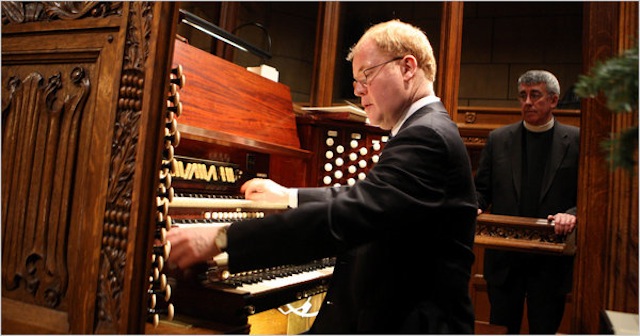 John Scott at the Saint Thomas Church organ, with now-Rector Emeritus Father Andrew C. Mead looking on